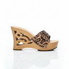 A single women's wedge sandal shown in side profile on a plain white background. The sandal features a light natural wood cutout wedge heel and platform, a leopard-print strap, and small silver studs.
