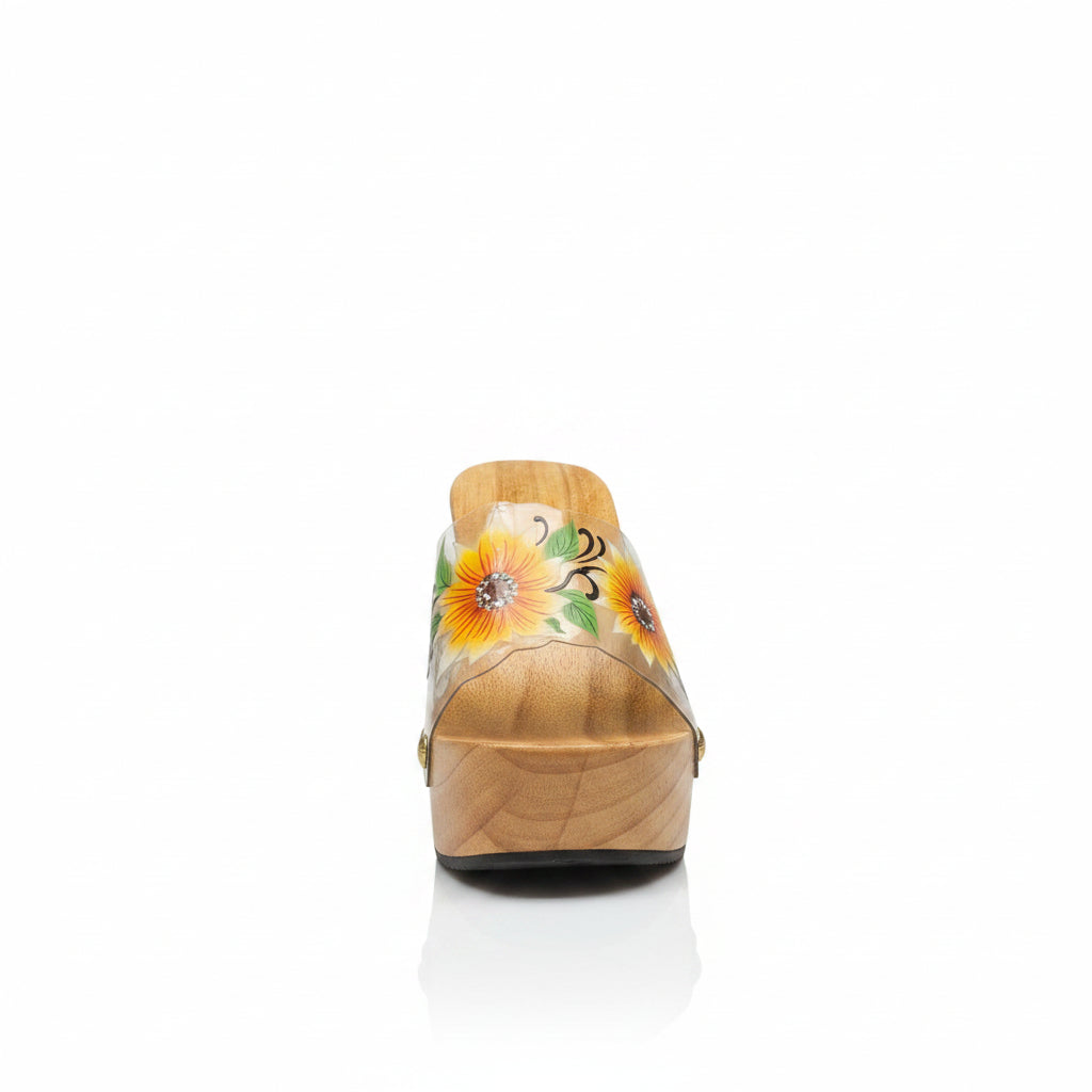 A single wooden wedge sandal with a carved natural wood platform and heel, featuring a clear strap decorated with a painted yellow sunflower and green leaves, set against a plain white background.