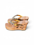 A pair of women's wedge sandals with carved natural wood platforms and heels, featuring gold-tone straps embellished with clear rhinestones, shown on a white background.