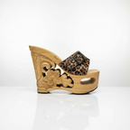 A single women's platform wedge sandal with a carved natural wood heel and sole, featuring a leopard print strap with a black buckle.